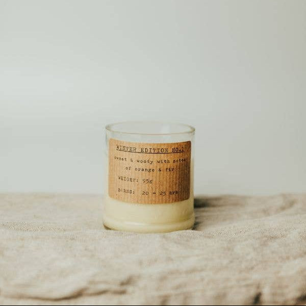Candle with a label on a textured surface