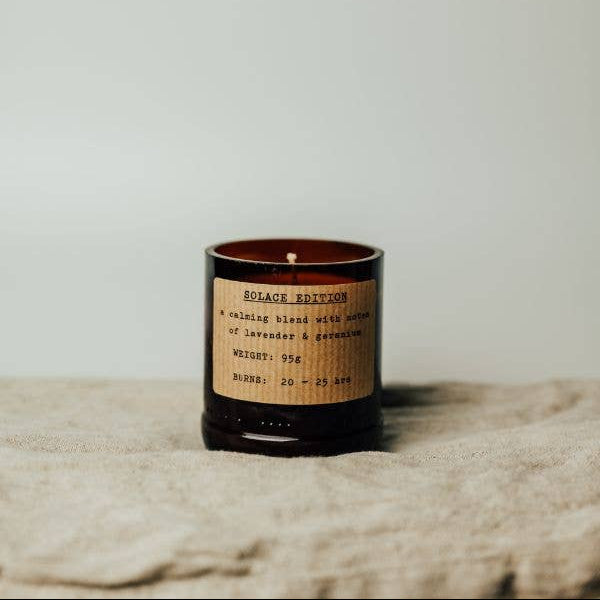 Candle with a label on a textured surface and light background
